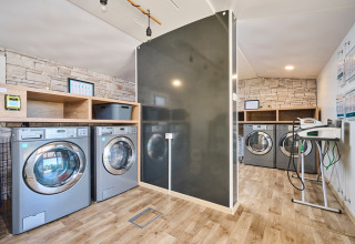 Modern laundry room at Camping Park Umag in Istria, Croatia, featuring washing machines and wood floors.