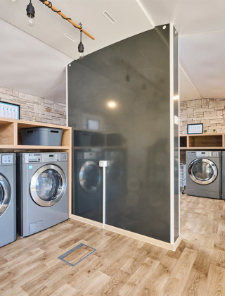 Moderner Waschraum im Camping Park Umag in Istrien, Kroatien, mit Waschmaschinen und Holzboden.