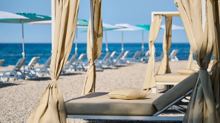 Luksuriøse liggestole med baldakin på stenstrand ved Camping Park Umag feriepark i Istrien, Kroatien.