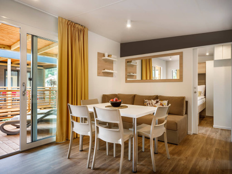 Moderna zona de comedor y estar en Lopar Garden Home, Valamar Camping San Marino, Croacia, con acceso a terraza.