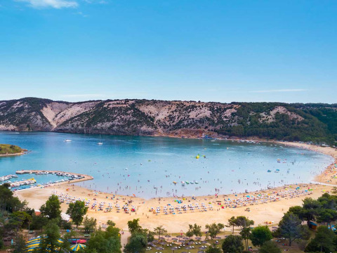 Spiaggia sabbiosa e baia panoramica affollata vicino a Lopar, Primorje-Gorski Kotar, Croazia.