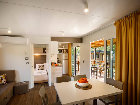 Intérieur moderne d’un lodge au Lopar Garden Home, Valamar Camping San Marino, Croatie, avec table et terrasse.
