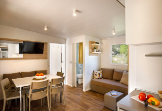 Soggiorno moderno al Lopar Garden Home di Valamar Camping San Marino, Croazia, con tavolo da pranzo e divano.