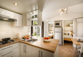 Moderne Küche mit Holzarbeitsplatte und Blick auf Schlafzimmer in San Marino Home im Valamar Camping San Marino.