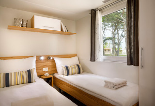 Modernes Zweibettzimmer mit hellem Holzdekor und Fenster, San Marino Home, Valamar Camping San Marino, Kroatien.