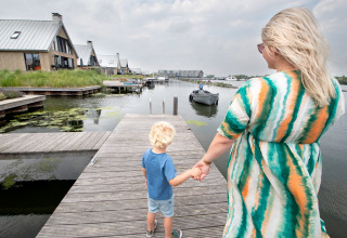 Moeder en kind wandelen hand in hand op een steiger bij het Oesterdam Resort in Zeeland, Nederland.
