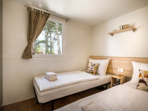 Habitación luminosa con dos camas individuales y ventana, en San Marino Home de Valamar Camping San Marino, Croacia.