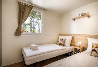 Helles Zimmer mit zwei Einzelbetten und Fenster, fotografiert im San Marino Home bei Valamar Camping San Marino, Kroatien.
