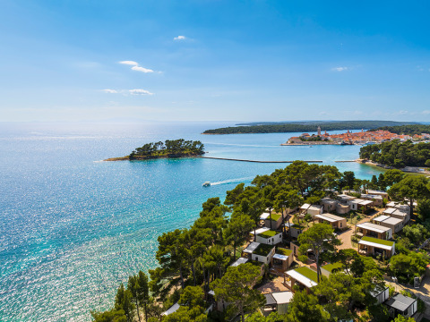 Vista aérea de Valamar Camping Padova con casas móviles, pinos y mar azul en Primorje-Gorski Kotar, Croacia.