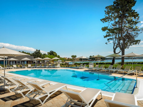 Außenpool mit Liegestühlen und Sonnenschirmen im Valamar Camping Padova, Primorje-Gorski Kotar, Kroatien.