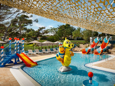 Kid-friendly pool area with colorful slides and playful figures at Valamar Camping Padova, Croatia.