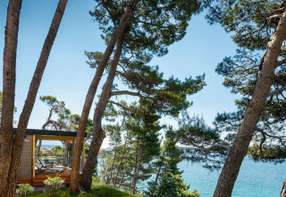 Udsigt over havet og træer fra en terrasse i Valamar Camping Padova, Primorje-Gorski Kotar, Kroatien.