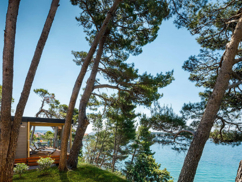 Uitzicht op zee en dennenbomen vanaf een terras bij Valamar Camping Padova, Primorje-Gorski Kotar, Kroatië.