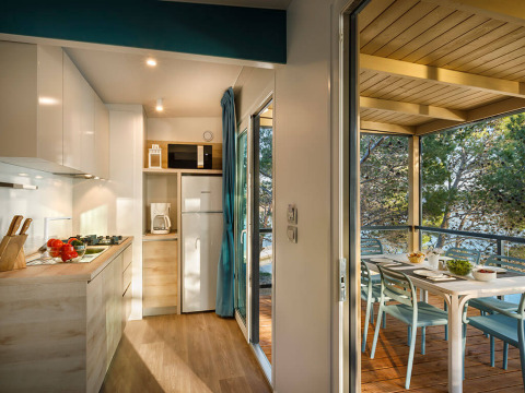 Cocina moderna y terraza con mesa de comedor en una casa vacacional de Valamar Camping Padova, Croacia.