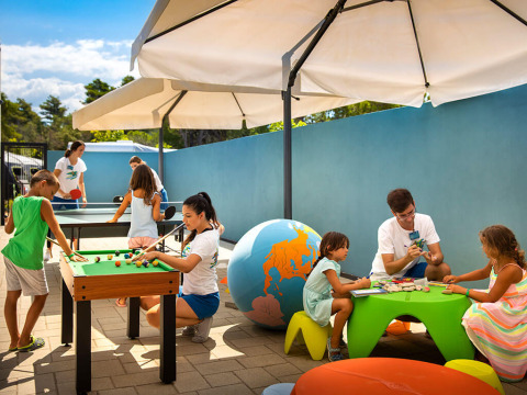 Bambini giocano e fanno attività creative all'aperto sotto gli ombrelloni a Valamar Camping Padova, Croazia.