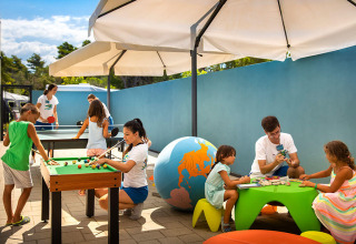 Kinder spielen und basteln im Freien unter Sonnenschirmen im Valamar Camping Padova, Kroatien.
