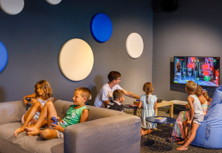 Kinderen spelen videogames in een kleurrijke speelkamer bij Valamar Camping Padova, Kroatië.