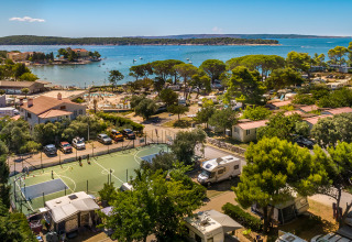 Vista aérea de Valamar Camping Padova con casas móviles, autocaravanas y playa en la costa de Croacia.