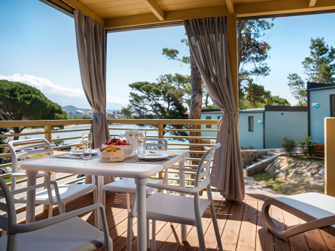 Terrasse mit Esstisch und Stühlen, Meerblick im Valamar Camping Padova, Primorje-Gorski Kotar, Kroatien.