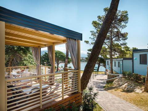 Udendørs terrasse ved Valamar Camping Padova med udsigt over havet og moderne hytter i Kroatien.