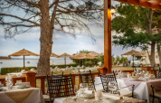 Zona pranzo all’aperto al Valamar Camping Padova con vista sulla spiaggia e ombrelloni in Croazia.