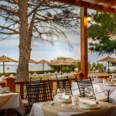 Outdoor dining area at Valamar Camping Padova overlooking the beach and parasols in Primorje-Gorski Kotar.
