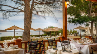 Outdoor dining area at Valamar Camping Padova overlooking the beach and parasols in Primorje-Gorski Kotar.