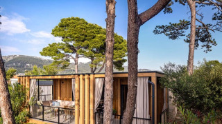 Lodge Hilltop Green Home rodeada de árboles y montañas, destacando su integración con la naturaleza.