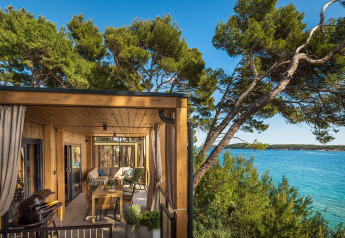Uitzicht vanaf Hilltop Green Home Spectacular seaview lodge met houten terras, zeezicht en groene bomen.
