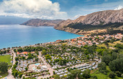 Vista aérea del parque vacacional Valamar Camping Baška en la costa de Primorje-Gorski Kotar, Croacia, con montañas.