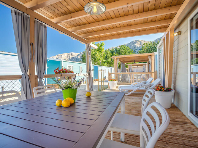 Udendørs terrasse ved Marena Home i Valamar Camping Baška, Kroatien, med solstole, bord og bjergudsigt.