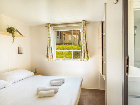Lichte slaapkamer in Brioni Superior Home Seaside bij Camping Brioni, Kroatië, met raam en moderne inrichting.
