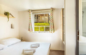 Bright bedroom at Brioni Superior Home Seaside, Camping Brioni, Croatia, featuring window and minimalist decor.