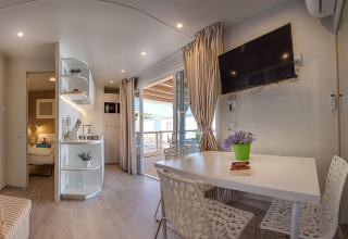 Hébergement moderne avec table à manger, kitchenette et terrasse au Valamar Camping Baška, Croatie.