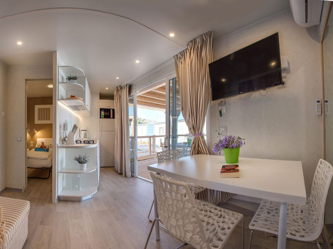 Hébergement moderne avec table à manger, kitchenette et terrasse au Valamar Camping Baška, Croatie.