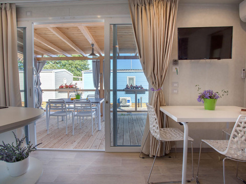 Casa de vacaciones moderna con terraza cubierta y comedor exterior en Valamar Camping Baška, Croacia.