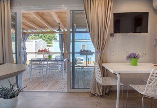 Modernes Ferienhaus mit überdachter Terrasse und Blick auf andere Hütten im Valamar Camping Baška, Kroatien.