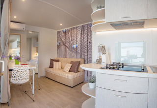 Modern holiday home interior at Valamar Camping Baška in Croatia, featuring a kitchen and cozy living area.