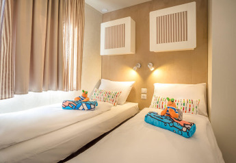 Camera moderna con due letti singoli, cuscini colorati e decorazioni per bambini al Marena Home, Croazia.
