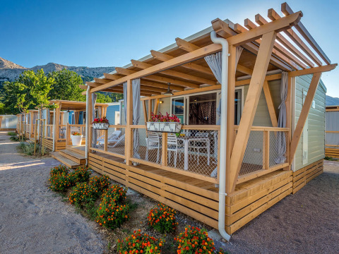 Mobil-homes modernes avec terrasse en bois et fleurs au Valamar Camping Baška, Primorje-Gorski Kotar, Croatie.