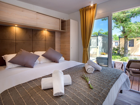 Moderne lodge Vela Bay Home bij Valamar Camping Baška in Kroatië met comfortabel bed en zicht op terras.