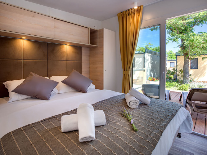 Moderne lodge Vela Bay Home bij Valamar Camping Baška in Kroatië met comfortabel bed en zicht op terras.