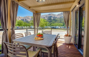 Buiteneetkamer bij Vela Bay Home lodge met uitzicht op bergen op Valamar Camping Baška in Kroatië.