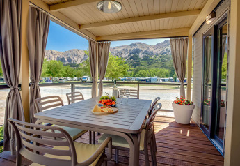 Zona pranzo esterna al Vela Bay Home con vista montagne al Valamar Camping Baška in Croazia.