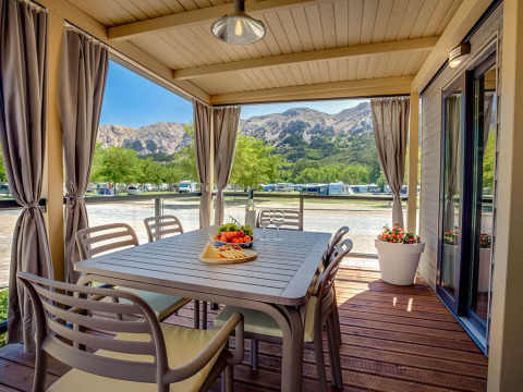 Udendørs spiseområde på Vela Bay Home-lodgen med udsigt til bjerge ved Valamar Camping Baška i Kroatien.