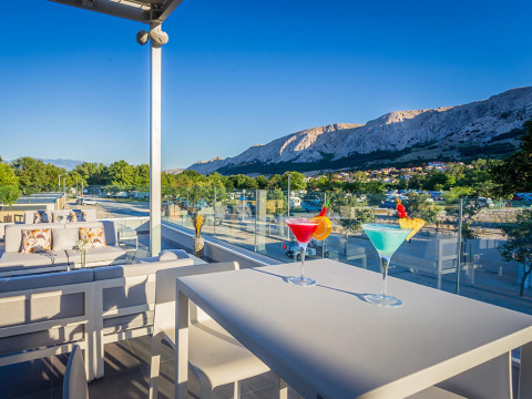 Terras met cocktails en uitzicht op de bergen bij Valamar Camping Baška, Primorje-Gorski Kotar, Kroatië.