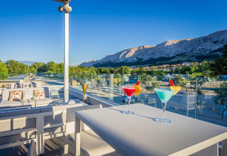 Terras met cocktails en uitzicht op de bergen bij Valamar Camping Baška, Primorje-Gorski Kotar, Kroatië.
