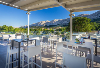 Terraza moderna al aire libre en Valamar Camping Baška con vista a montañas en Primorje-Gorski Kotar, Croacia.