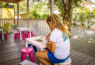 Niños dibujando y jugando en mesas exteriores en Valamar Camping Baška, Primorje-Gorski Kotar, Croacia.