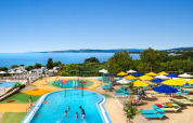 Espace piscine pour enfants, parasols colorés et vue sur la mer au Valamar Camping Krk en Croatie.